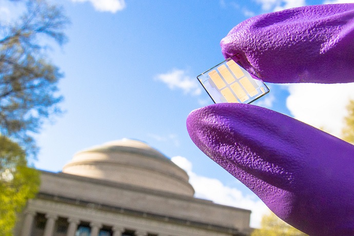 Researcher displays a sample of the record-setting new solar cell on the MIT campus