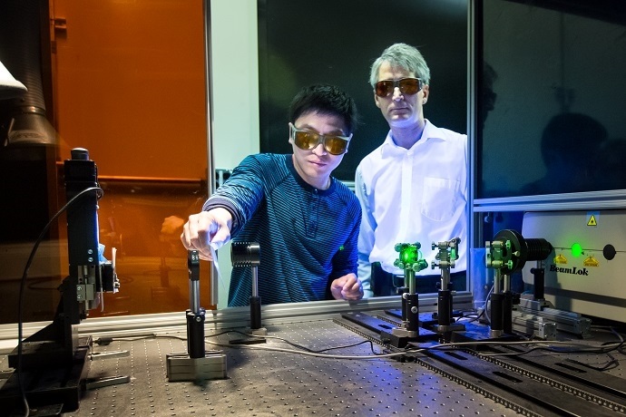 Adrian Sabau and Jian Chen work with a laser