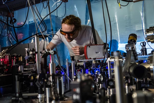 Rice University atomic physicist Joe Whalen works on a laser cooling system for ultracold strontium gas