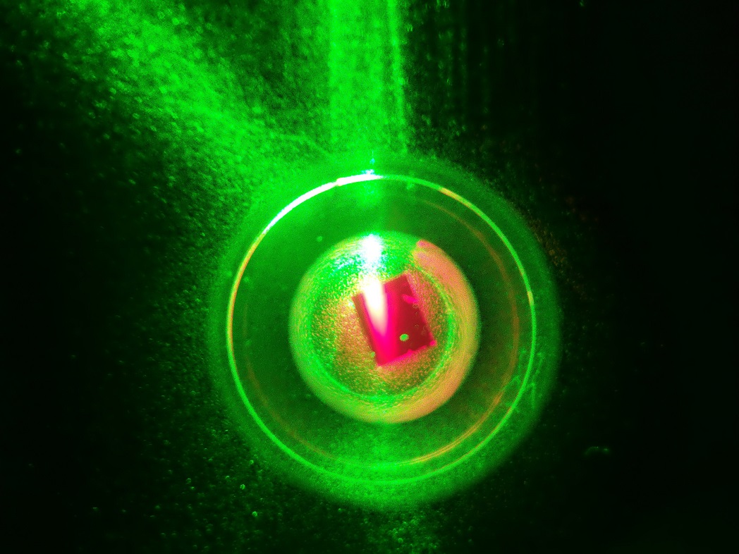 The diamond is held inside a sapphire ring and illuminated by 532-nm green laser