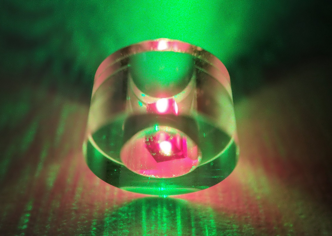 The diamond is held inside a sapphire ring and illuminated by 532-nm green laser.