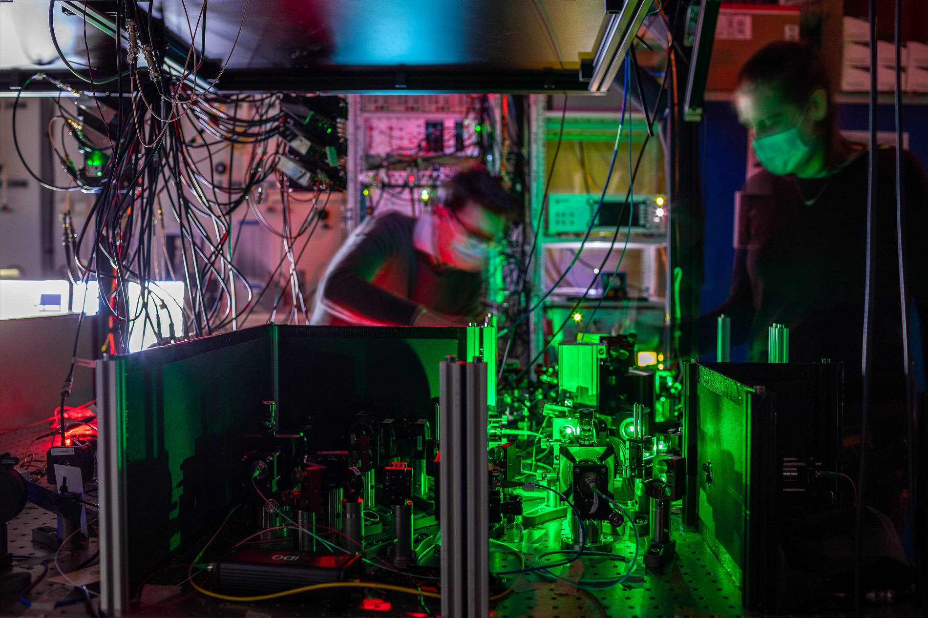 Researchers work on one of the quantum network nodes, where mirrors and filters guide the laser beams to the diamond chip.