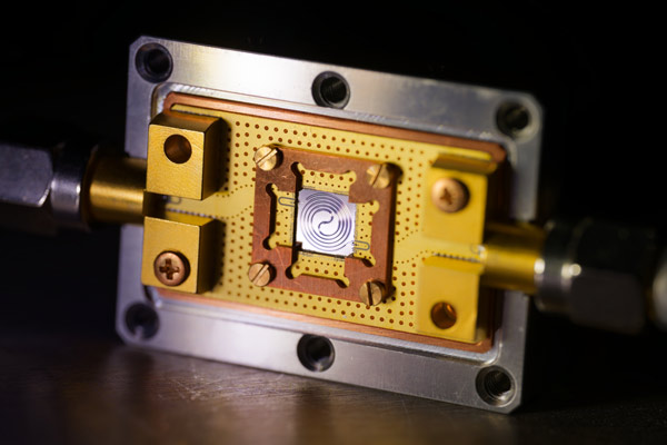 A long, spiral-wound waveguide with a fine-tapered, fishbone-like structure can amplify photon signals from quantum computing qubits with very low noise