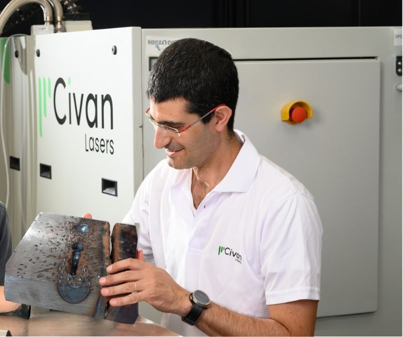 A Civan Lasers team member proudly displays a 100mm thick steel section cut using the 120kW Dynamic Beam Laser, showcasing the advanced capabilities of their cutting-edge laser technology.