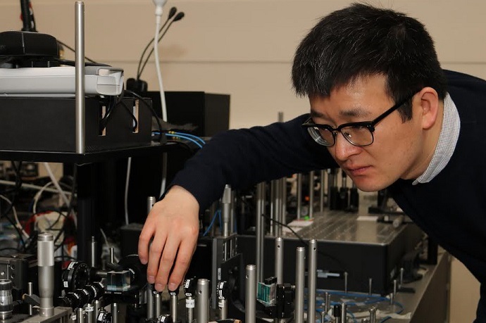 Bristol PhD student Xiaogang Qiang and the primitive photonic quantum processor he designed with UWA researchers to simulate quantum walks