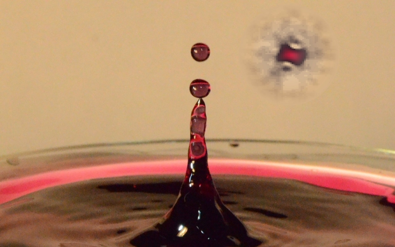 Image of a liquid quantum droplet as a false-color image next to classical water droplets