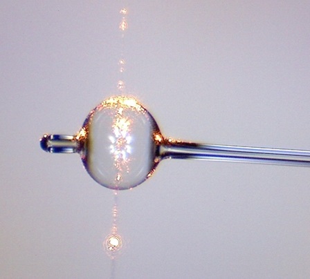 An example of a microbubble resonator with an optical fibre running vertically next to it to excite the mode