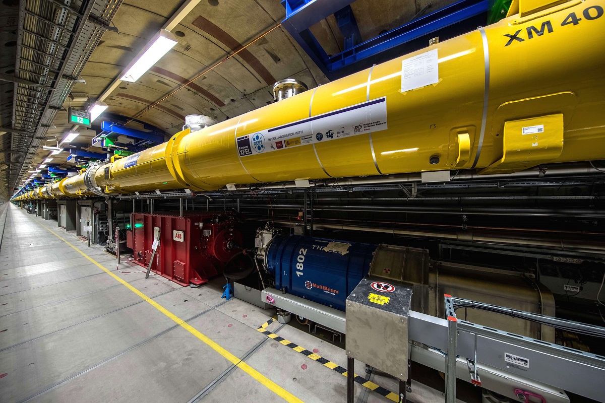View into the 2.1-kilometre long accelerator tunnel of European XFEL with the yellow superconducting accelerator modules hanging from the ceiling
