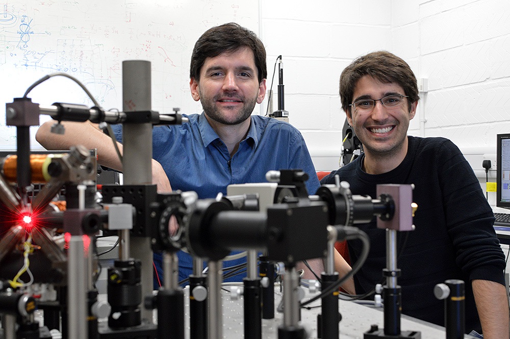 Amalio Fernández-Pacheco, principal investigator of the project (left) and Dédalo Sanz-Hernández, lead autor of the work (right) posing with the optical system used at the University of Cambridge to read information from 3D magnetic nanostructures