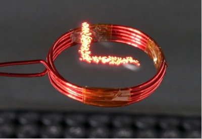 Luciola is a light-emitting particle with a diameter of 3.5mm and a weight of 16.2mg moving in mid-air in a 10.4cm x 10.4cm x 5.4cm space through acoustic levitation using two 40-kHz 17 x 17 ultrasonic transducer arrays placed face-to-face at a distance of 20cm and wirelessly powered by 12.3-MHz resonant inductive coupling.