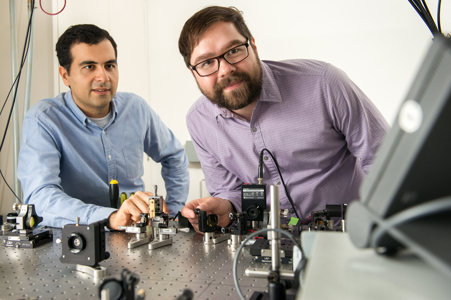 Alireza Marandi, left, and Marc Jankowski prepare to carry out experiments at the optical bench