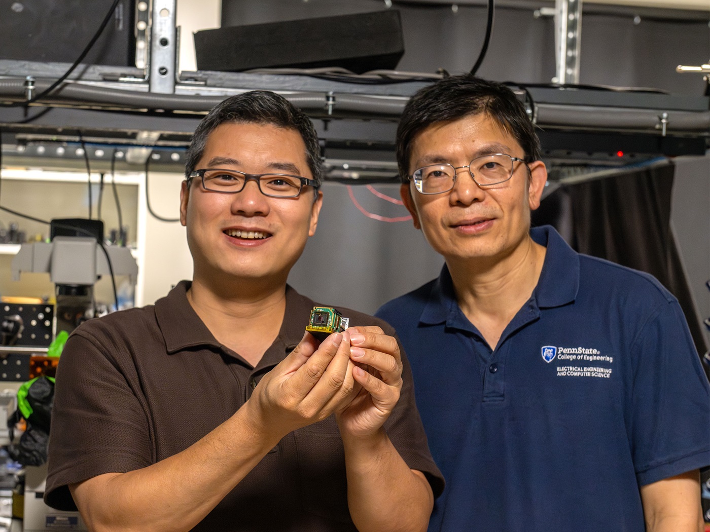 Xingjie Ni, left, associate professor of electrical engineering, displays a camera sensor integrated with a three-millimeter-by-three-millimeter metasurface.