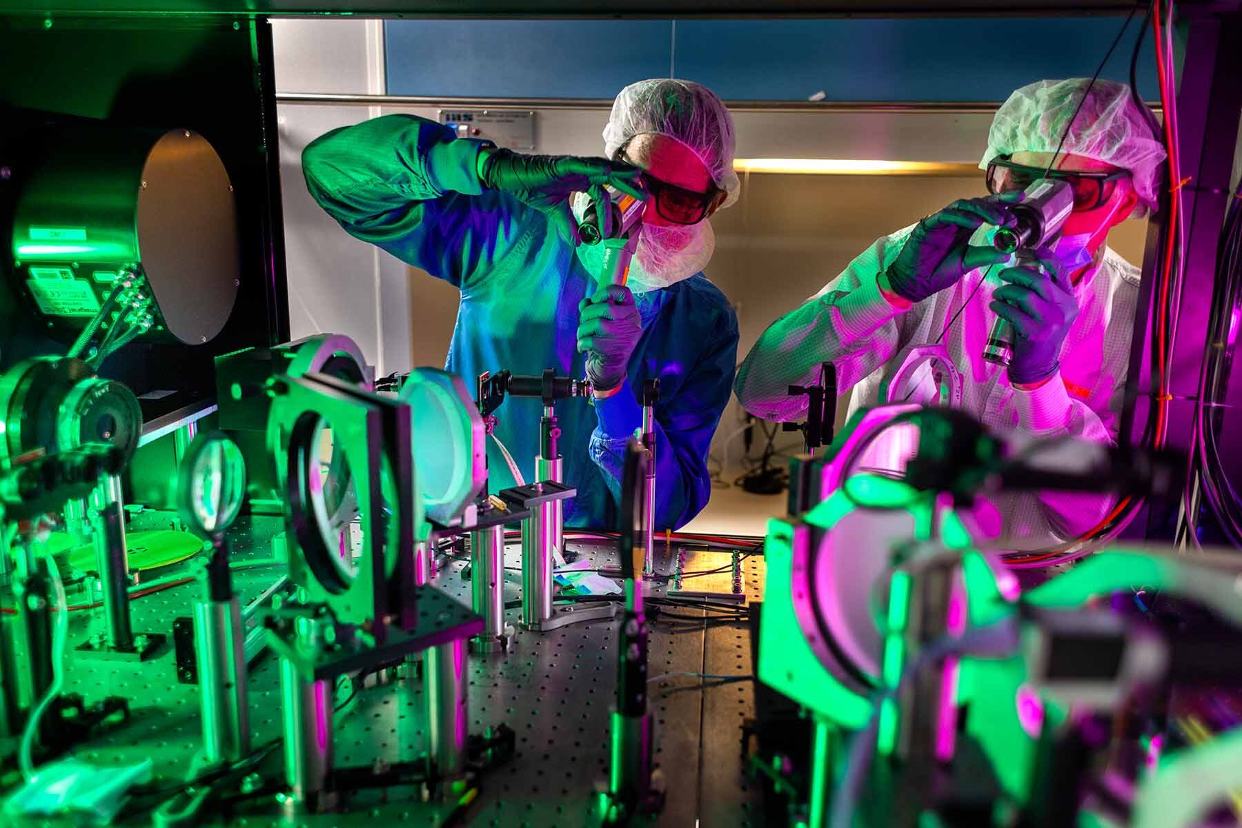 John Nees, left, and laser engineer Richard Van Camp, right, check the alignment of the optics inside the cabinet where the amplification of the laser pulses occurs. At two petawatts, ZEUS is now the most powerful laser in the U.S.